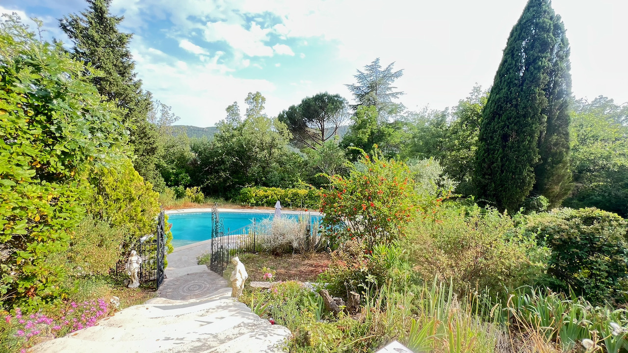 Portail en fer forgé ouvrant sur le jardin et l'accès piscine