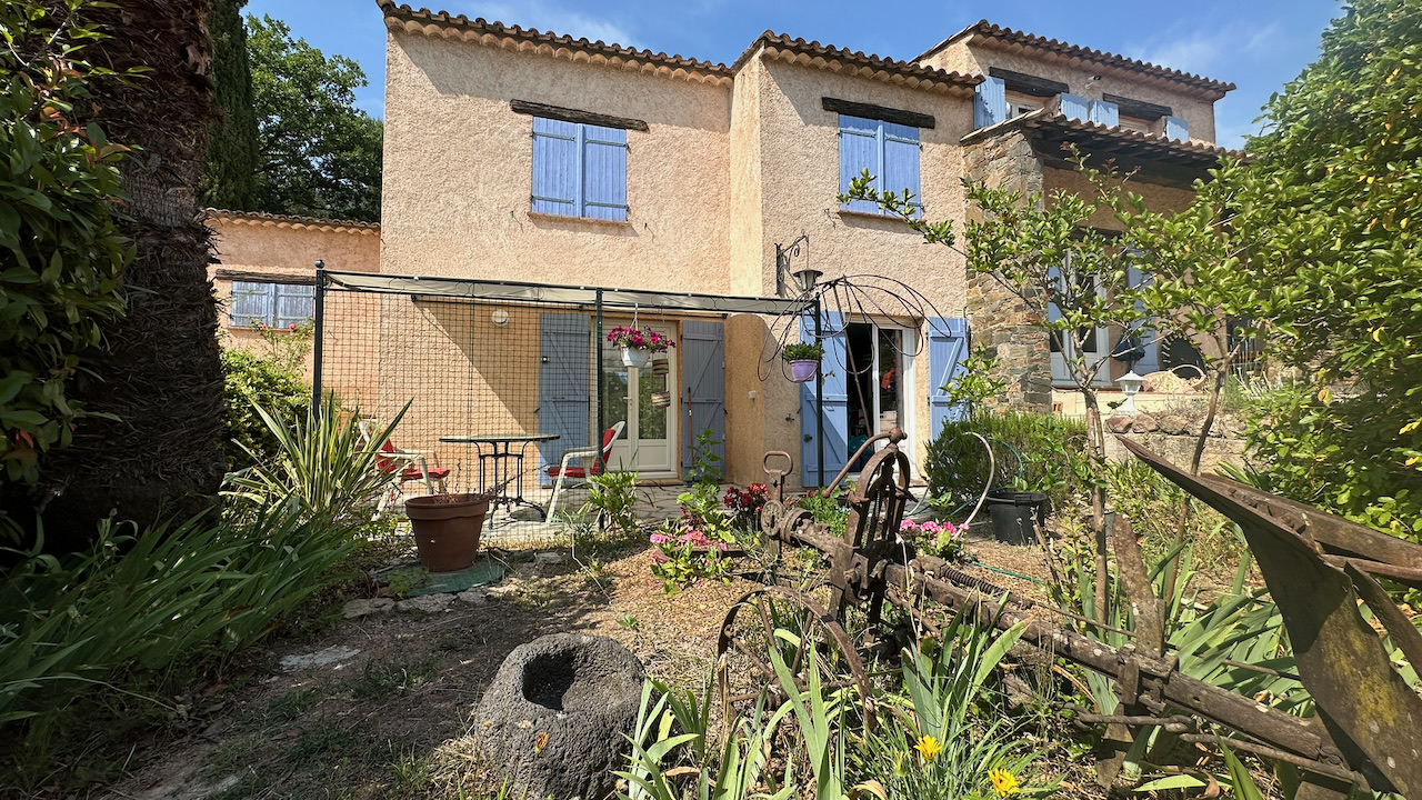 Façade du mas provençal avec palmiers et volets bleus