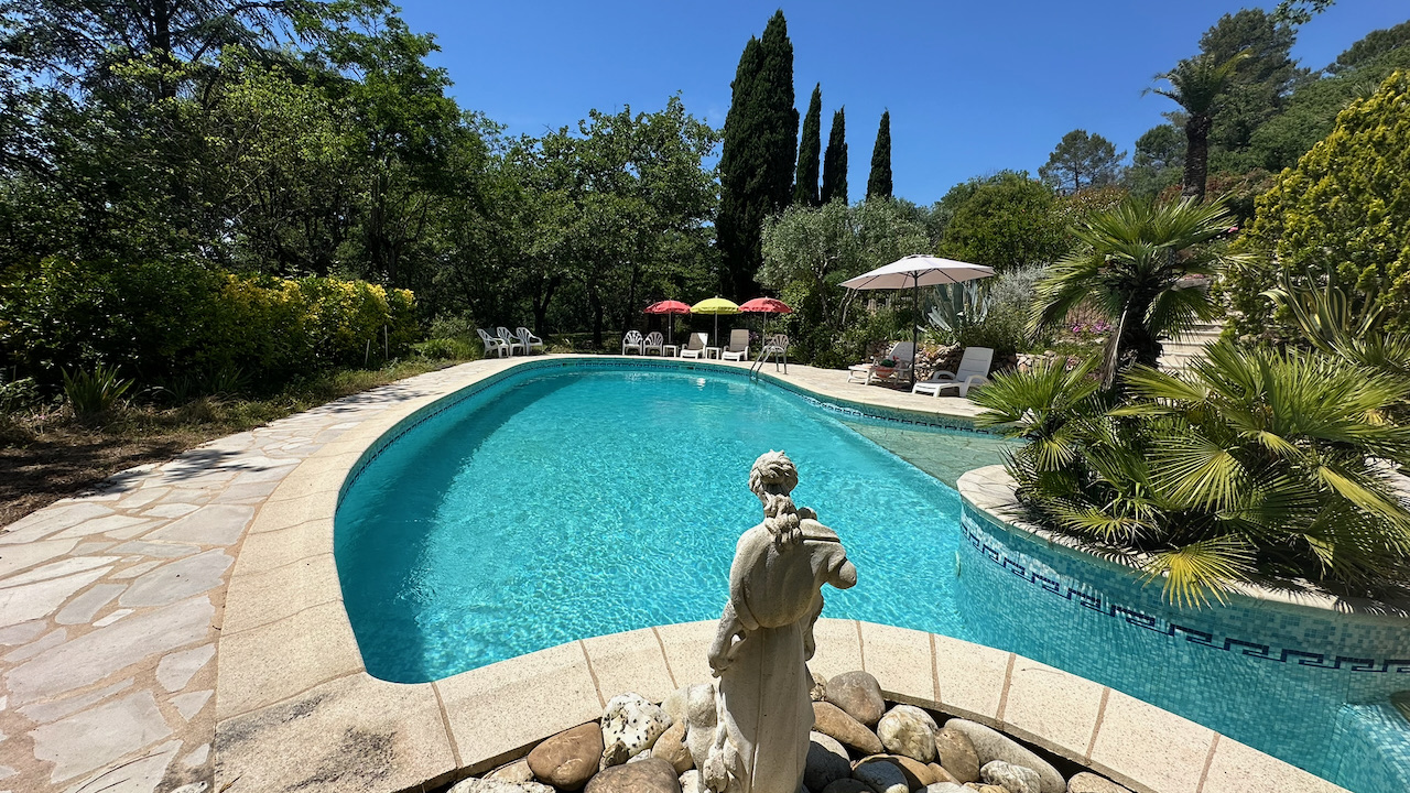 Piscine avec statue, eau turquoise et cyprès en Provence