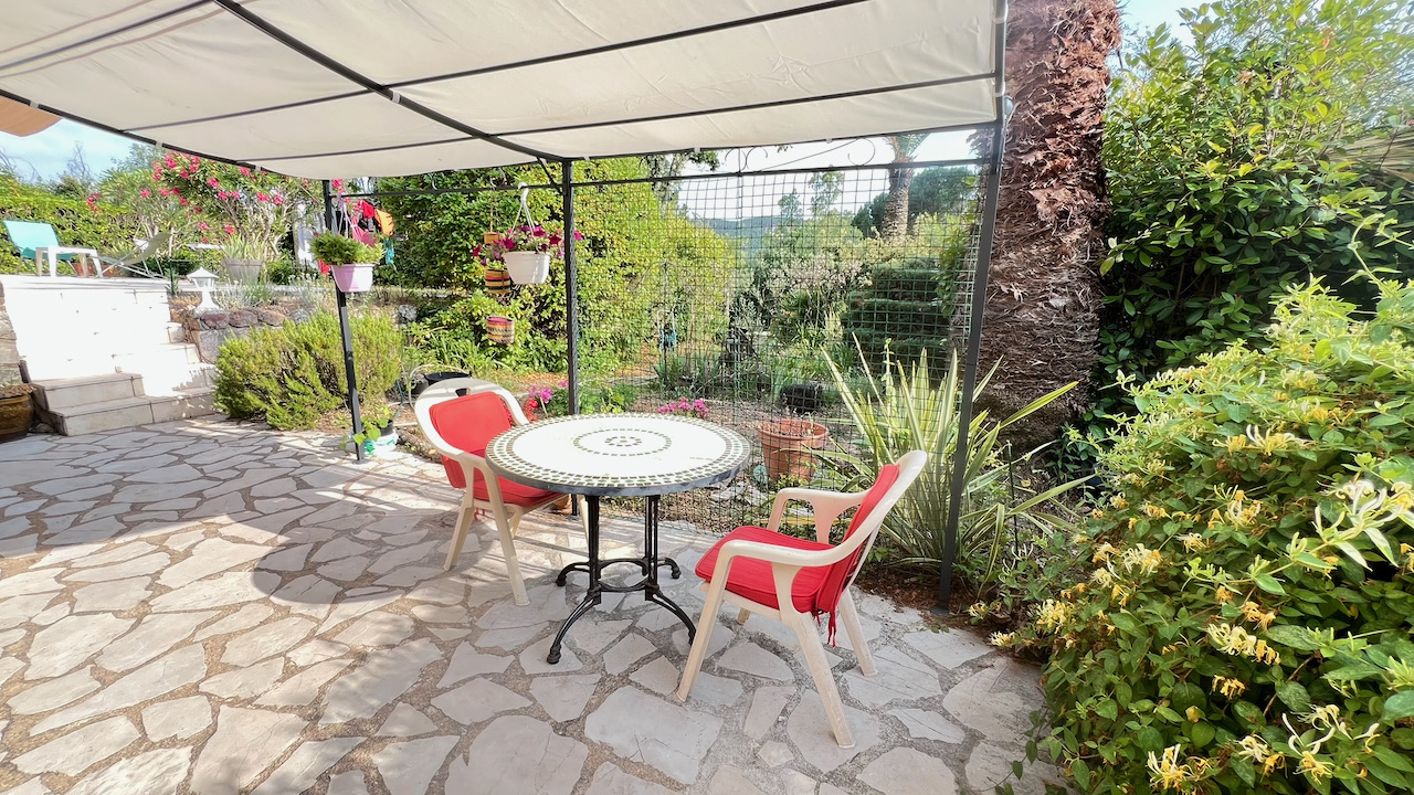 Terrasse couverte avec table mosaïque et coin repas ombragé